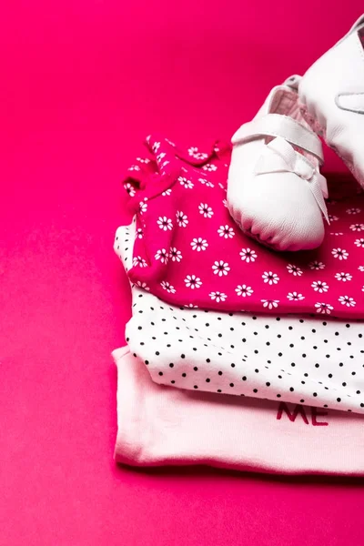 Διπλωμένο ροζ κορμάκι με παπούτσια πάνω σε μινιμαλιστικό ροζ φόντο. πάνα για νεογέννητο κοριτσάκι. Στοίβα της βρεφικής ένδυσης. Στολή του παιδιού — Φωτογραφία Αρχείου