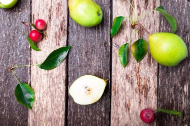 Armut ve ahşap rustik arka plan üzerinde küçük elma. Üstten Görünüm. Çerçeve. Sonbaharda hasat.