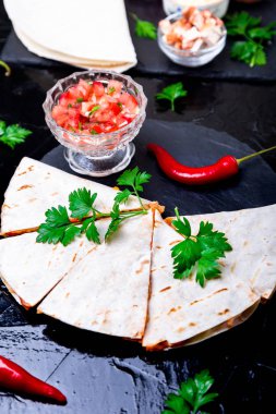 Mexican quesadilla siyah arduvaz taş plaka üzerinde salsa sos ile. Biber biber.