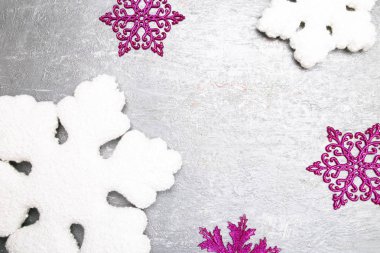 Dekoratif beyaz ve pembe gri arka plan üzerinde kar tanesi. Noel tebrik kartı. Uzay kopyalayın. Üstten Görünüm.