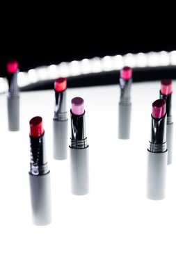 Mat ruj kırmızı ve doğal renkleri beyaz ve siyah arka plan üzerinde ayarlayın. Moda renkli ruj. Profesyonel makyaj ve güzellik. Yanıp sönen bokeh arka plan.