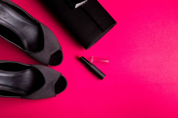 Fashion Lady Accessories Set. Black and pink. Minimal. Black Shoes, lipstick and bag on pink background. Flat lay.