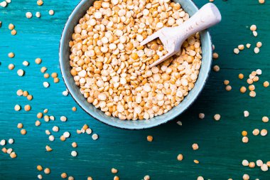 Yeşil zemin üzerine yeşil kase kuru sarı bezelye. Üstten Görünüm.