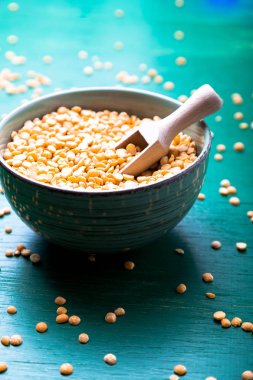 Yeşil zemin üzerine yeşil kase kuru sarı bezelye. Yakın çekim.