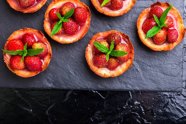 Tartas de fresas caseras en plato de pizarra, fondo negro. Vista superior . — Foto de Stock