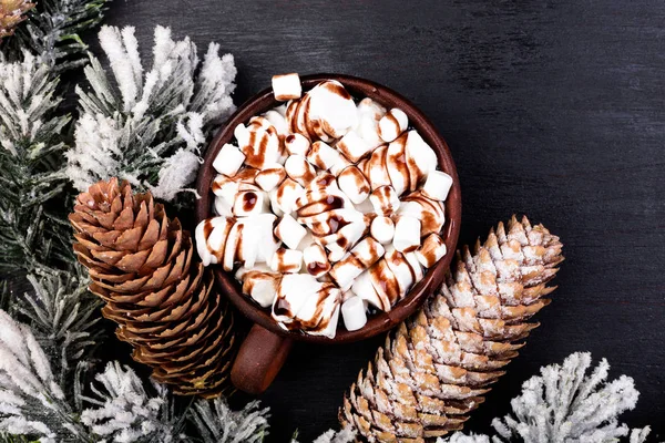 Nourriture de Noël Guimauve sucrée au chocolat dans une tasse brune sur fond noir. Couché plat — Photo