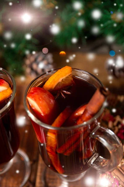 Χριστουγεννιάτικο ζεστό κρασί με φρούτα και μπαχαρικά σε ξύλινο τραπέζι. — Φωτογραφία Αρχείου