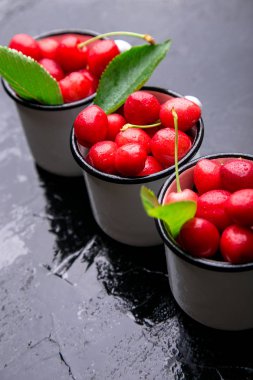 Kiraz emaye Kupası siyah arka plan üzerine. Sağlıklı, yaz meyve. Kiraz.