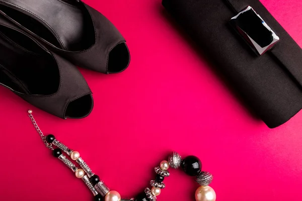 Набір модних аксесуарів для леді. Чорно-рожевий. Мінімум. Чорне взуття, браслет і сумка на рожевому тлі. Плоский прошарок . — стокове фото