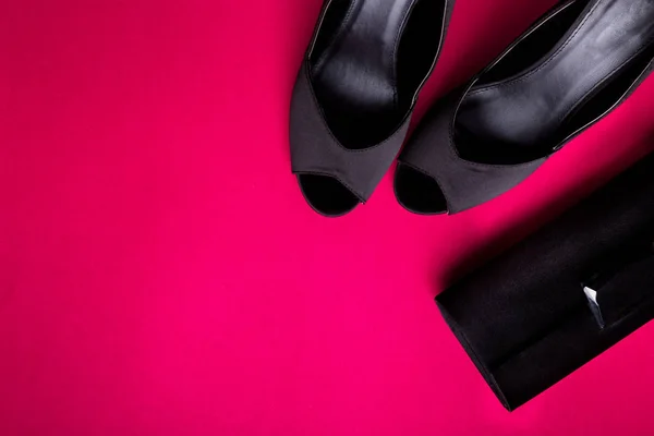 时尚女装配件套装。黑色和粉红色。最小.黑色的鞋子和粉红色的背景袋。平躺. — 图库照片