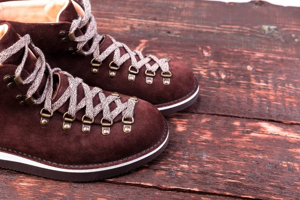 Botas de gamuza marrón sobre fondo de madera. Zapatos de otoño o invierno . — Foto de Stock