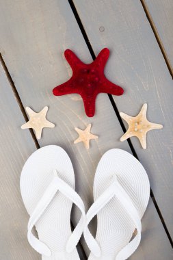 Flip flop gri ahşap arka plan deniz kabuklarını ve beyaz. Düz yatıyordu.