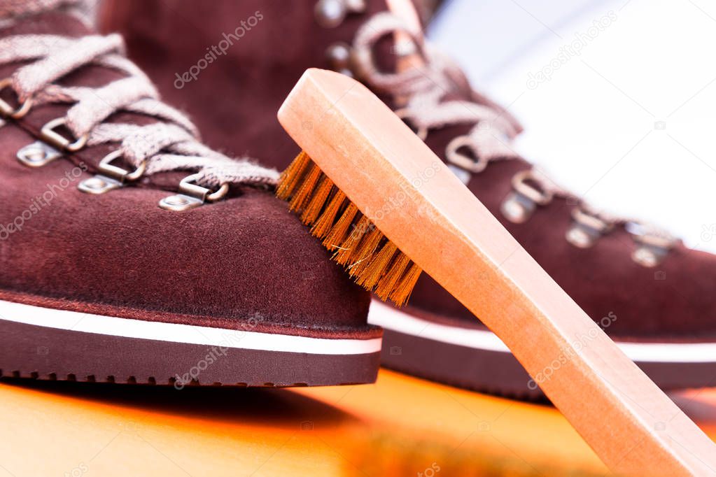 Brown man suede boots with brush. Macro. Clean shoes