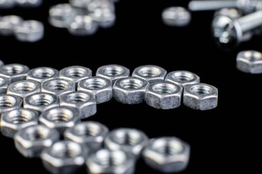 Metal somun, cıvata siyah arka plan üzerine. Düz yatıyordu. Makro.