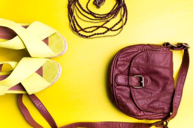 Kadının şeyler aksesuarlar yaz sezonu için kümesi. Kahverengi çanta sarı Platform sandaletler, kolye. Düz Lay.