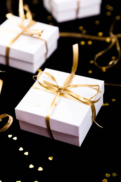 White gift boxes with gold ribbon on shine background. Close up. — Stock Photo, Image