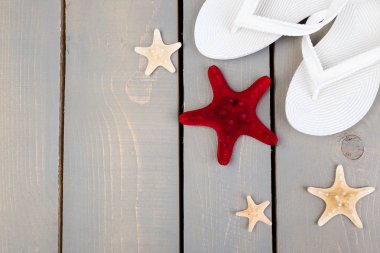 Flip flop gri ahşap arka plan deniz kabuklarını ve beyaz. Düz yatıyordu.