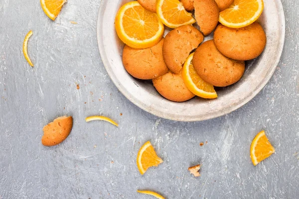 Cookies en oranje citrusvruchten op metalen plaat op de grijze achtergrond. Plat leggen — Stockfoto