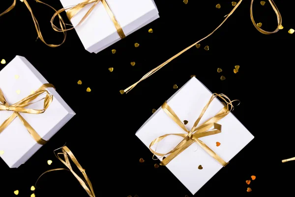 Cajas de regalo blancas con cinta dorada sobre fondo brillante. Puesta plana — Foto de Stock