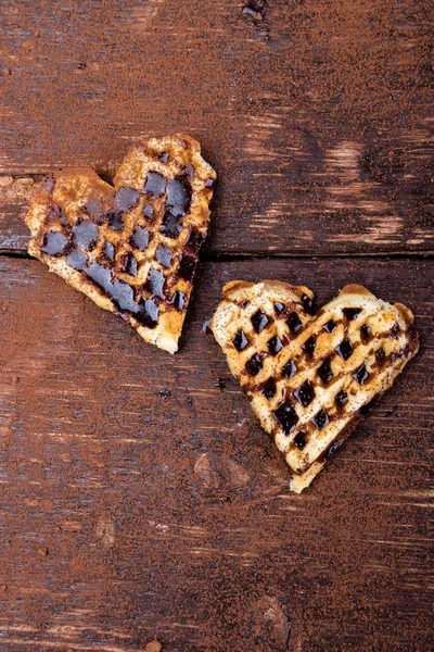 Dua wafel berbentuk hati belgian dengan coklat di latar belakang kayu. Berbaringlah. Salin ruang — Stok Foto