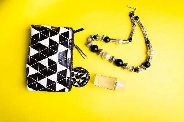 Woman handbag with makeup and accessories on yellow background. Flat lay — Stock Photo, Image