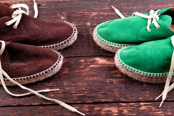 Green and brown suede espadrille shoes on wooden background. — Stock Photo, Image