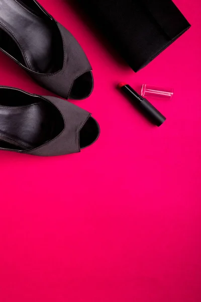 Набір модних аксесуарів для леді. Чорно-рожевий. Мінімум. Чорне взуття, помада та сумка на рожевому тлі. Плоский прошарок . — стокове фото