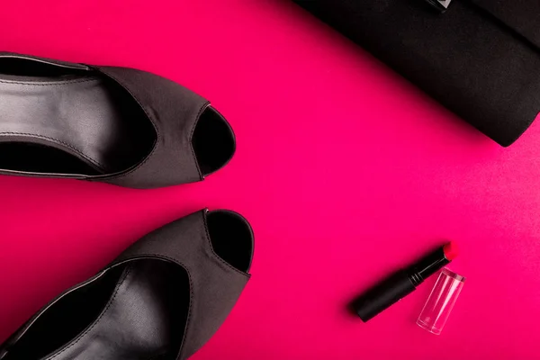 Набір модних аксесуарів для леді. Чорно-рожевий. Мінімум. Чорне взуття, помада та сумка на рожевому тлі. Плоский прошарок . — стокове фото