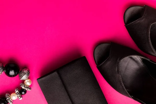 Набір модних аксесуарів для леді. Чорно-рожевий. Мінімум. Чорне взуття, браслет і сумка на рожевому тлі. Плоский прошарок . — стокове фото