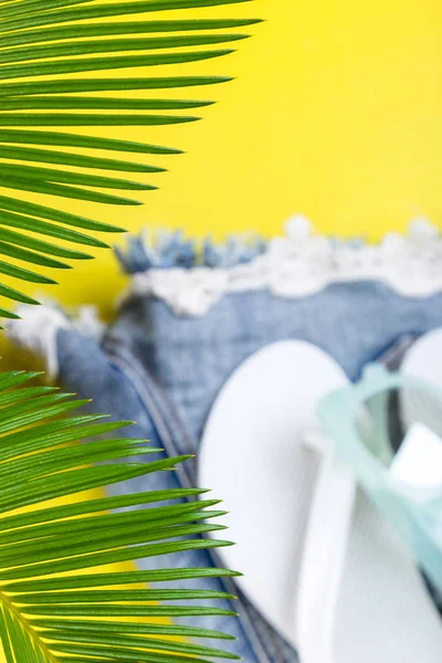 Tropischen Hintergrund Palmen Zweige mit verschwommenen Satz von Damensachen Accessoires zur Strandsaison. — Stockfoto