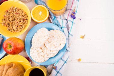 Sağlıklı kahvaltı. Çeşitli ürün yelpazesine sahip küme. Portakal suyu, Granola, kruvasan, kahve ve meyve.