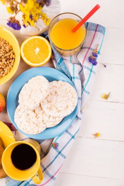 Sağlıklı kahvaltı. Çeşitli ürün yelpazesine sahip küme. Portakal suyu, Granola, kruvasan, kahve ve meyve.