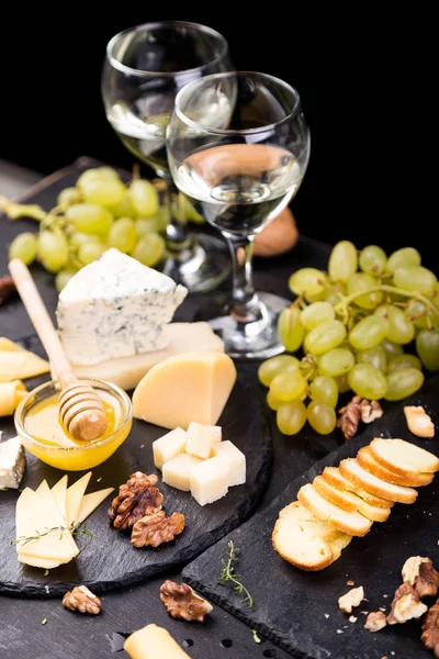 Cheese plate. Assortment of cheese with walnuts, bread an honey on stone slate plate. — Stock Photo, Image