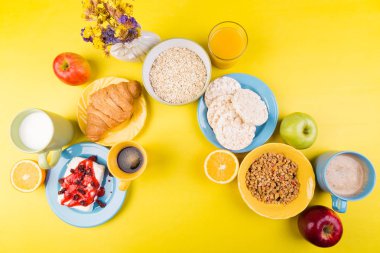 Sağlıklı kahvaltı. Çeşitli ürün yelpazesine sahip küme. Portakal suyu, Granola, kruvasan, kahve ve meyve.