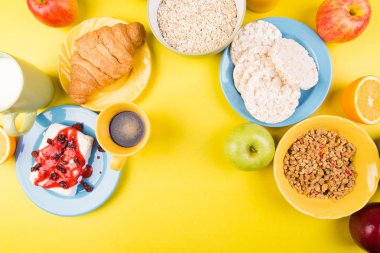 Sağlıklı kahvaltı. Çeşitli ürün yelpazesine sahip küme. Portakal suyu, Granola, kruvasan, kahve ve meyve.