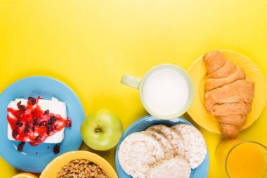 Sağlıklı kahvaltı. Çeşitli ürün yelpazesine sahip küme. Portakal suyu, Granola, kruvasan, kahve ve meyve.