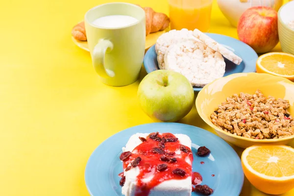 Sağlıklı kahvaltı. Çeşitli ürün yelpazesine sahip küme. Portakal suyu, Granola, kruvasan, kahve ve meyve.