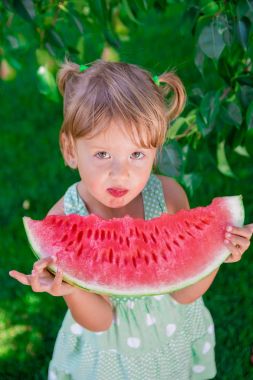Küçük kız büyük dilim karpuz ile. Yaz. Açık. Üstten Görünüm