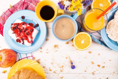 Sağlıklı kahvaltı. Çeşitli ürün yelpazesine sahip küme. Portakal suyu, Granola, kruvasan, kahve ve meyve.