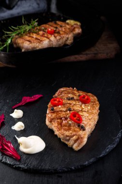 Izgara domuz biftek kayrak plaka üzerinde.