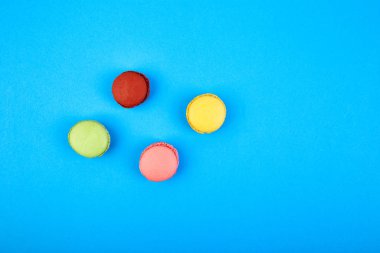Tatlı tatlı Macaron veya mavi kağıdı arka plan, renkli badem çerezler, kek acıbadem kurabiyesi. Tebrik kartı. Kadın gün ya da anneler günü. Bahar. Düz yatıyordu. Uzay kopyalayın. Minimalizm