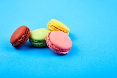 Tatlı tatlı Macaron veya mavi kağıdı arka plan, renkli badem çerezler, kek acıbadem kurabiyesi. Tebrik kartı. Kadın gün ya da anneler günü. Bahar. Uzay kopyalayın. Minimalizm