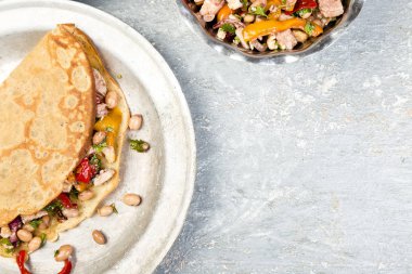 Tuzlu karabuğday krep beyaz fasulye, kırmızı ve sarı biber, maydanoz ve tavuk. Mexican Quesadilla. Üstten Görünüm. Kopya alanı.