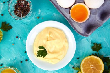 Ev yapımı Sos mayonez ve malzemeler yumurta, yağ, limon, mavi zemin üzerine mustar. Top vie