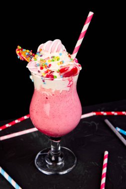 Berry, rasberry, çilek, çikolata şekerleme, lolipop siyah arka plan üzerine pembe aşırı milkshake... Deli freakshake. Uzay kopyalayın. Gıda trend Overshake