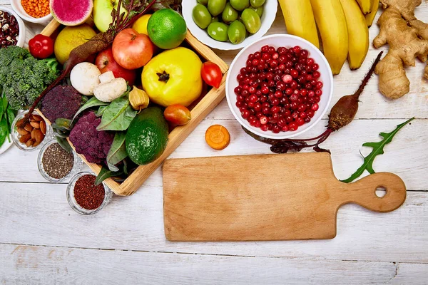 Seleção de superalimentos em torno de tábua de corte sobre fundo branco . — Fotografia de Stock