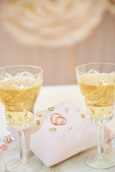 杯のシャンパンと結婚指輪の枕 — ストック写真