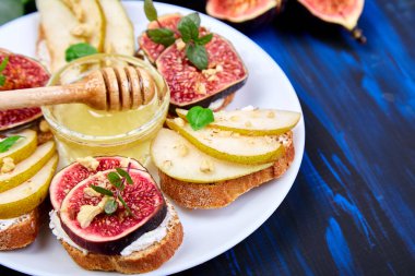 Armut, ricotta peyniri, bal, incir, fındık ve şifalı otla Kahvaltı tostları ya da atıştırmalık sandviçler. Antipasto. İtalyan yemeği. Üst Manzara. Boşluğu kopyala.