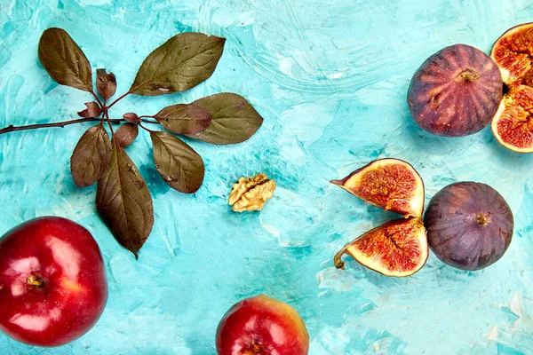 Autumn frame background. Autumn food still life with season fruits grape, red apples and figs on a blue table. Thanksgiving da