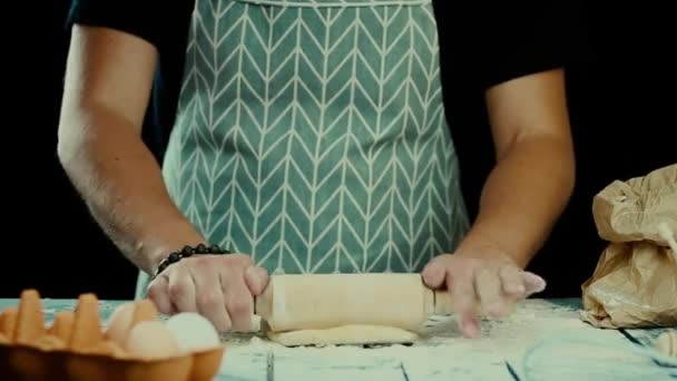 Baker χέρια προετοιμασία φρέσκια ζύμη με πλάστη στο τραπέζι της κουζίνας. Ο άνθρωπος σχηματίζει τη ζύμη σε μια αλευρωμένη επιφάνεια. Μαγειρική ζυμαρικά, μακαρόνια, πίτσα έννοια τροφίμων — Αρχείο Βίντεο